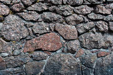 Pattern of grey wall surface, made of artificial stone of different sizes