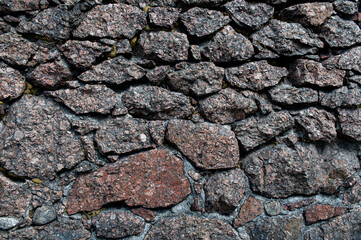 Pattern of grey wall surface, made of artificial stone of different sizes