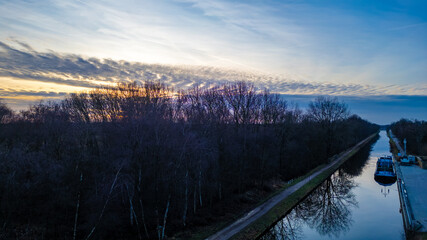 This image captures the serene transition from day to night as twilight descends over a calm canal...