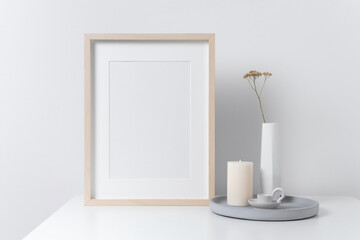 Blank wooden portrait picture frame mockup with copy space in white room interior