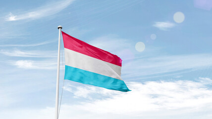 Luxembourg national flag cloth fabric waving on the sky.