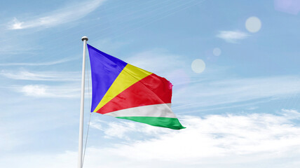 Seychelles national flag cloth fabric waving on the sky.