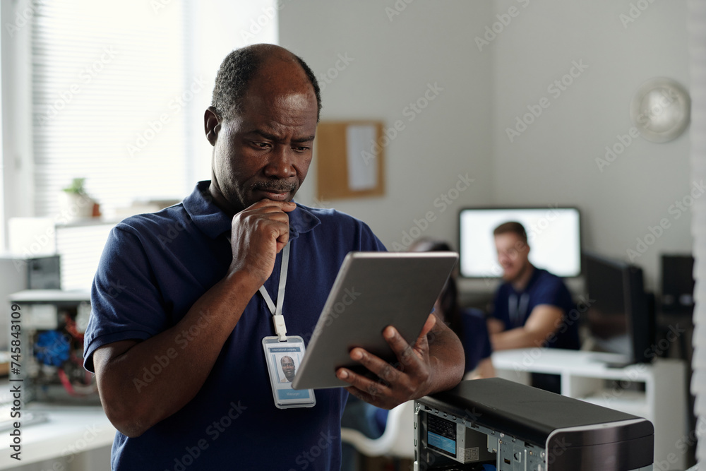 Poster serious experienced technician of repair center looking through points of online technical instructi
