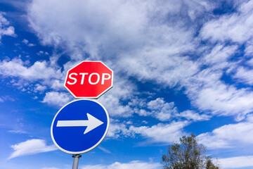 Stop sign overlaying right turn sign, creating a dynamic urban scene. Concept of decisions in the city.