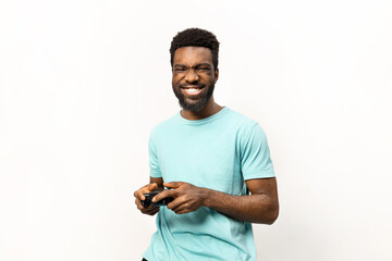 Joyful African American male in casual attire enjoying video gaming, showcasing emotions. Ideal for technology and lifestyle-related content. - 745845504