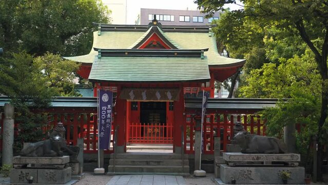 神社の境内にある朱塗りの天神さまの拝殿と牛の像