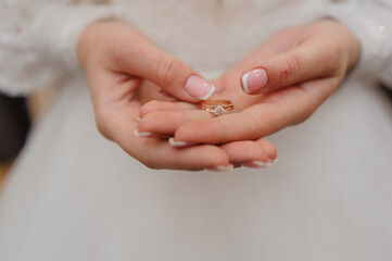 Gold ring with a diamond in the hands of the bride. Gold ring with moissanite in woman's hands