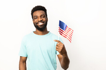 African American man smiles while holding an American flag, representing patriotism and positive feelings, isolated on a white background. - 745846709