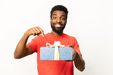 Afro American man in red shirt pointing at a present. Concept of surprise, reward, and joyful moments isolated on white background. - 745848546