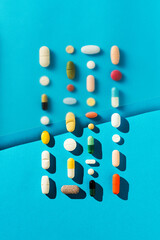 Colorful pills on blue background, medical background