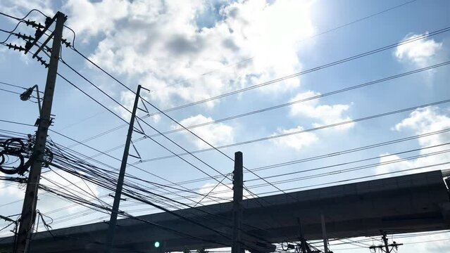 Construction Highway, Electric Poles, Electric Lines And Light Pole On Light Blue Sky Backgrounds With Movement Clouds, Sunlight And Birds Fly At Rama2 Road Bangkok Thailand