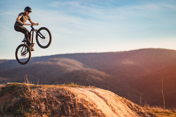 Young man on a mountain bike performing a dirt jump