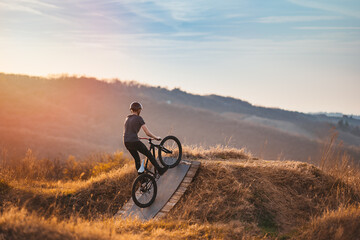 Young man on a mountain bike performing a dirt jump - Powered by Adobe