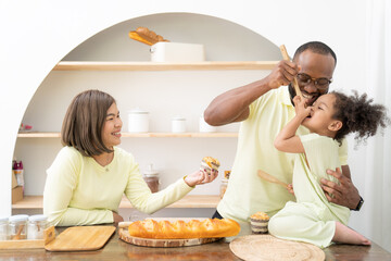 Happy African American family doing activities with daughter at home.