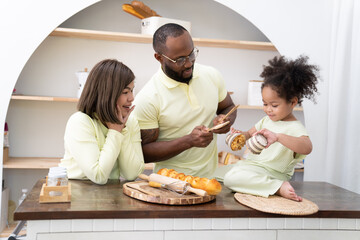 Happy African American family doing activities with daughter at home.