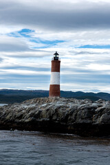 end of the world lighthouse in ushuaia argentina on an island of rocks in the beagle channel  
