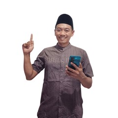 Cheerful young Asian Muslim man showing mobile phone blank screen recommending App isolated over white background