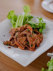 The favorite dish of Thailand, spicy pork liver salad (Tub wan) served with mint leaves and fresh vegetables. Its taste is salty and sour from the seasoning and sweet and tender from pork liver.