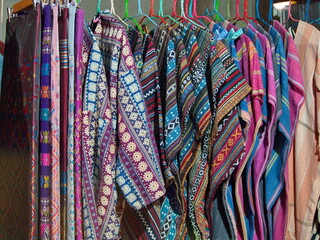 Brightly colored hand-woven skirts and beautifully patterned sarongs are sold at the souvenir center. Beautiful patterned fabric woven by hill tribes in northern Thailand. Hill tribe style clothes.
 - obrazy, fototapety, plakaty