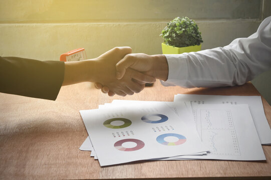 Man and woman are shaking hands in office. Business strategy concept.