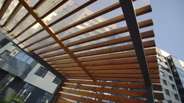 Gazebo with chairs and table protects from sun near high-rise buildings. Corner for family relaxation located right in courtyard