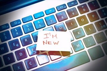 I am new written on a memo on the keyboard at the office