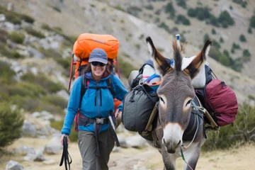 Fotobehang  hiker with a donkey carrying camping gear  © Denis