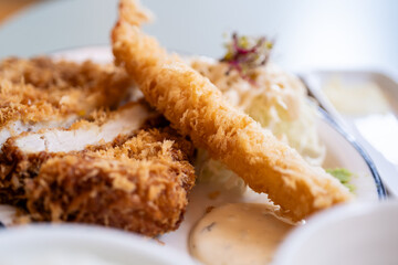 Pork cutlets and fried shrimp, garnished with lemon and vegetable salad