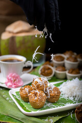 Steamed palm-sugar cupcake with grated coconut on top.