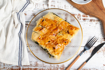 Spinach pastry. Pastry product. Spinach pie on a white background. local name ispanakli borek. Top view