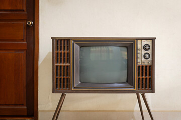 Retro old TV with blank screen standing in the room at home. vintage television with legs, front view