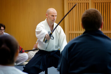 master showing off bokken sword technique to attentive class