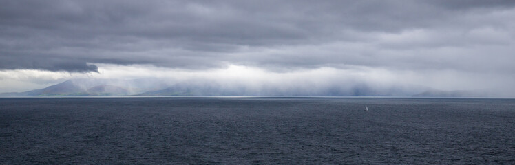 A storm and light through clouds during a cloudy day in the Dingle peninsula in County Kerry, Ireland