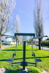 Pair of outdoor gym workout towers in urban park, inviting outdoor fitness. Lively city neighborhood backdrop.