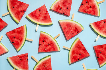 Watermelon slice popsicles on a blue background