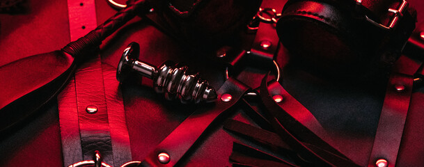 set of BDSM sex toys with handcuffs, whip flogger, butt anal plug for submission and domination on...