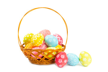 Easter basket filled with colorful eggs isolated on white background. Easter celebration concept. Colorful easter handmade decorated Easter eggs.