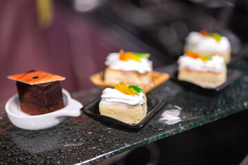 Small pieces of various tasty cake, there are placed on the international buffet meal. Sweet dessert food object photo, Close-up and selective focus.