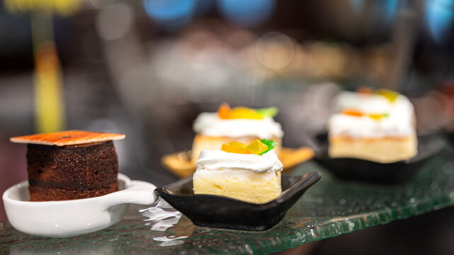 Small pieces of various tasty cake, there are placed on the international buffet meal. Sweet dessert food object photo, Close-up and selective focus.