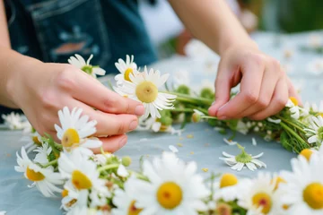 Tuinposter person creating a flower crown with daisies © Natalia