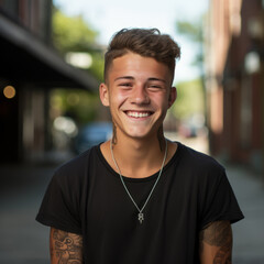 Portrait of a happy teen boy with tattoos. Smiling tattooed young man standing on the street looking at the camera. Outdoor shot of a man with tattoos looking forward. - 745921777