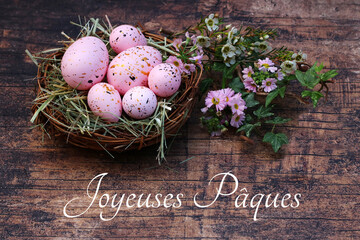 Joyeuses Pâques: Nid de Pâques avec fleurs et œufs sur fond de bois ancien avec le texte...