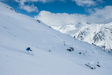 Skiing in deep powder snow in the mountains of Austria during winter, blue sky, in Hochfügen, mountain scenery in background. - 745924347