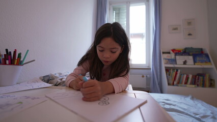 Concentrated Little Girl Drawing on Paper in Bedroom, Child Using Pen. Artistic childhood development, leisure time