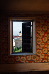 Intérieur abandonné. Vue sur le clocher d'Epinal. Papier peint vintage. Maison des années 70 abandonnée. Fenêtre ouverte sur le passé. Décoration des années 70. Papier peint fleuri.