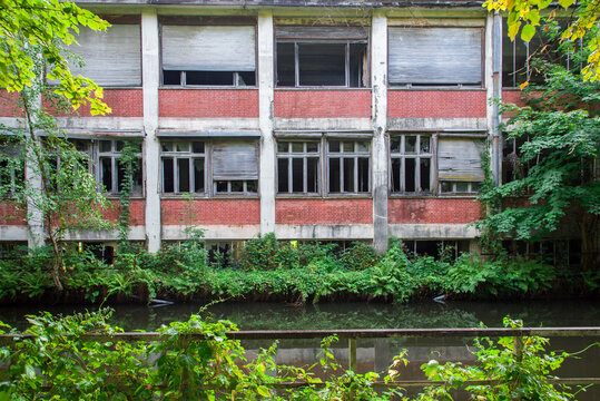 Usine abandonn&eacute;e dans les Vosges. Pass&eacute; industriel &agrave; Epinal. Ancienne usine industriel. Vieille usine au bord d'une rivi&egrave;re. Industrie des Vosges. Nature reprend ses droits.