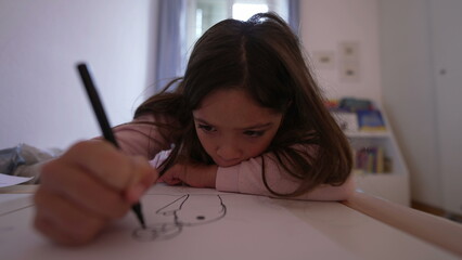 One focused little girl drawing on paper with pen. Childhood development, artistic craft time. Child having leisure time