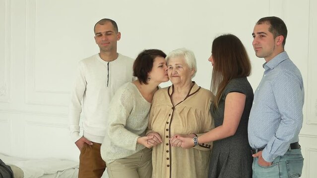 Photographer is taking pictures of an elderly woman with her grandchildren. The beautiful multi-generations family enjoys togetherness 