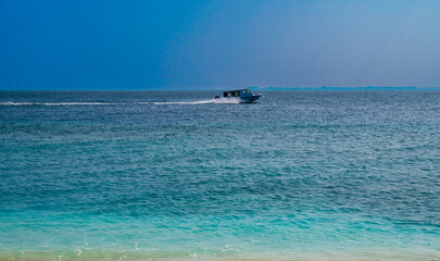 White boat floats fast on the surface of the sea.