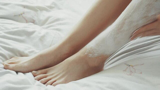 woman shaves her legs with a razor